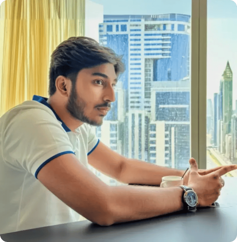 Nikesh seated beside a window